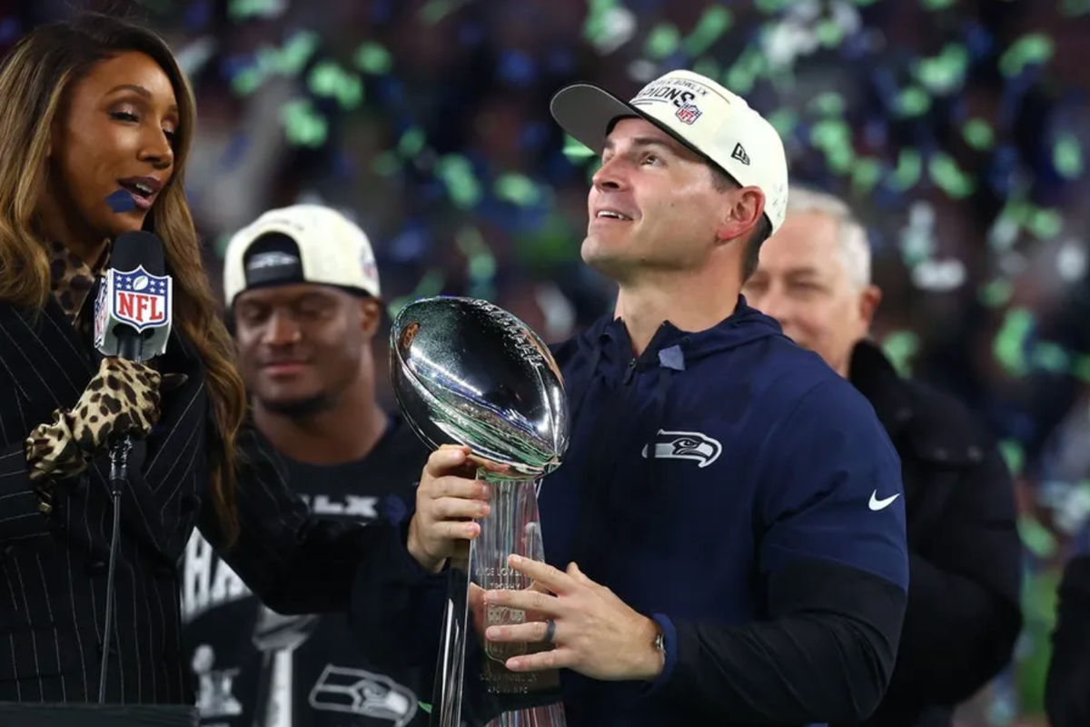 Feb 8, 2026; Santa Clara, CA, USA; Seattle Seahawks head coach Mike MacDonald celebrates with the Vince Lombardi trophy on the podium after defeating the New England Patriots in Super Bowl LX at Levi's Stadium. Mandatory Credit: Mark J. Rebilas-Imagn Images