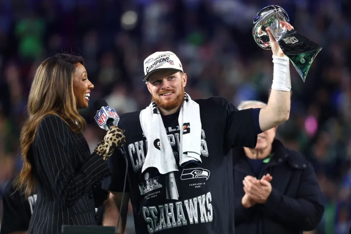 Feb 8, 2026; Santa Clara, CA, USA; Seattle Seahawks quarterback Sam Darnold (14) celebrates with the Vince Lombardi trophy on the podium after defeating the New England Patriots in Super Bowl LX at Levi's Stadium. Mandatory Credit: Mark J. Rebilas-Imagn Images