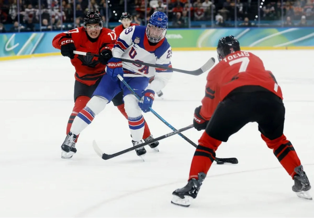 Feb 22, 2026; Milan, Italy; Brock Nelson (29) of the United States is defended by Macklin Celebrini (17) of Canada and Devon Toews (7) of Canada in the men's ice hockey gold medal game during the Milano Cortina 2026 Olympic Winter Games at Milano Santagiulia Ice Hockey Arena. Mandatory Credit: Geoff Burke-Imagn Images