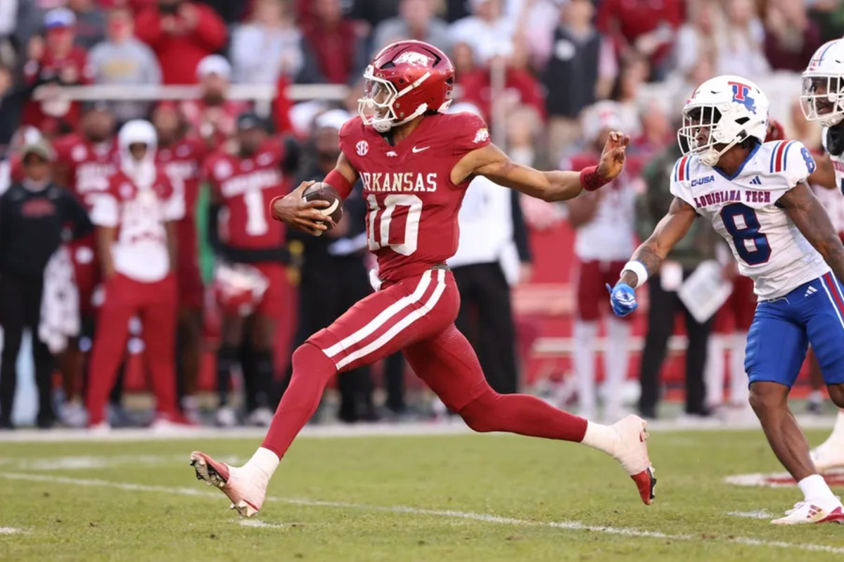 23 de noviembre de 2024; Fayetteville, Arkansas, EE. UU.; El mariscal de campo de los Arkansas Razorbacks, Taylen Green (10), anota un touchdown mientras el back defensivo de los Louisiana Tech Bulldogs, Demarcus Griffin-Taylor (8), defiende en el Estadio Donald W. Reynolds de los Razorbacks. Crédito obligatorio: Nelson Chenault-Imagn Images