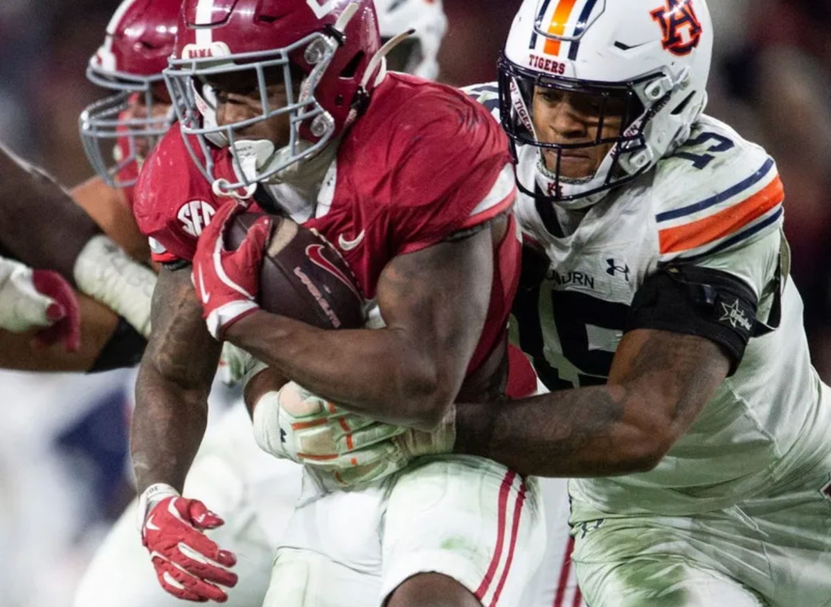 Auburn Tigers defensive lineman Keldric Faulk (15) takes down Alabama Crimson Tide running back Jam Miller (26) as Auburn Tigers take on Alabama Crimson Tide at Bryant-Denny Stadium in Tuscaloosa, Ala., on Saturday, Nov. 30, 2024. Alabama Crimson Tide defeated Auburn Tigers 28-14.