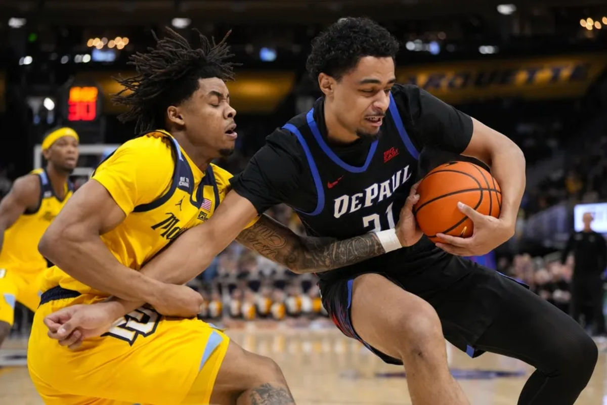 1º de março de 2026; Milwaukee, Wisconsin, EUA; O ala do DePaul Blue Demons, Theo Pierre-Justin (21), segura a bola longe do armador do Marquette Golden Eagles, Nigel James Jr. (0), durante o primeiro tempo no Fiserv Forum. Crédito obrigatório: Jeff Hanisch-Imagn Images
