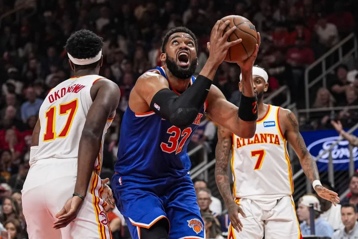 25 de abril de 2026; Atlanta, Geórgia, EUA; O pivô do New York Knicks, Karl-Anthony Towns (32), tenta alcançar a cesta contra o ala do Atlanta Hawks, Onyeka Okongwu (17), durante o primeiro tempo na State Farm Arena. Crédito obrigatório: Dale Zanine-Imagn Images