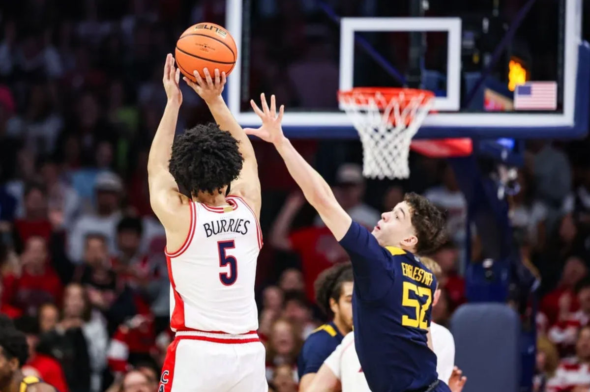 24 de enero de 2026; Tucson, Arizona, EE. UU.; El base de los Arizona Wildcats, Brayden Burries (5), anota un triple sobre el base de los West Virginia Mountaineers, Treysen Eaglestaff (52), durante la primera mitad del partido en el McKale Memorial Center. Crédito obligatorio: Aryanna Frank-Imagn Images