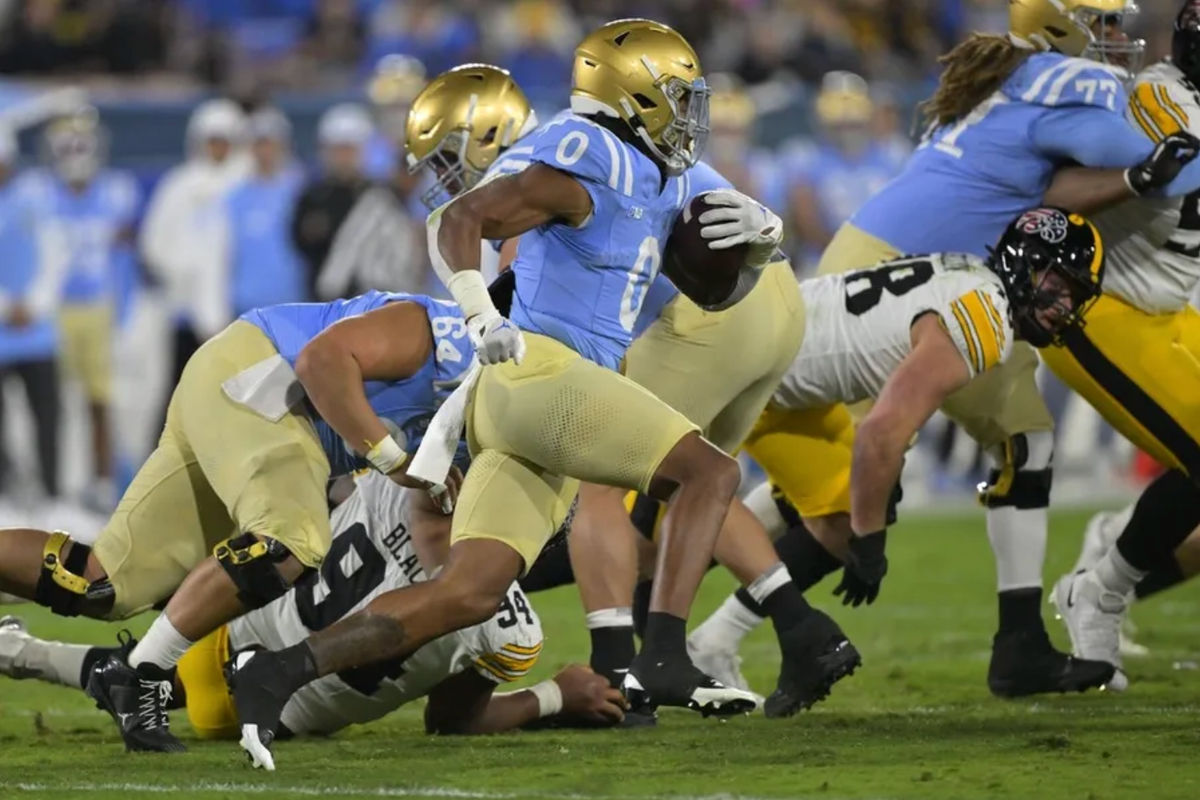 8 de novembro de 2024; Pasadena, Califórnia, EUA; O running back do UCLA Bruins, Jalen Berger (0), avança com a bola no primeiro tempo contra o Iowa Hawkeyes no Rose Bowl. Crédito obrigatório: Jayne Kamin-Oncea-Imagn Images