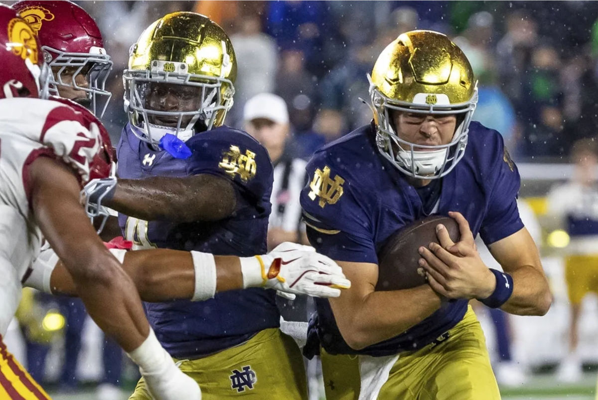 18 de octubre de 2025; South Bend, Indiana, EE. UU.; El mariscal de campo de los Notre Dame Fighting Irish, CJ Carr (derecha), corre con el balón mientras el corredor Jeremiyah Love (4) lo bloquea durante la segunda mitad en el estadio de Notre Dame. Crédito obligatorio: Michael Caterina-Imagn Images
