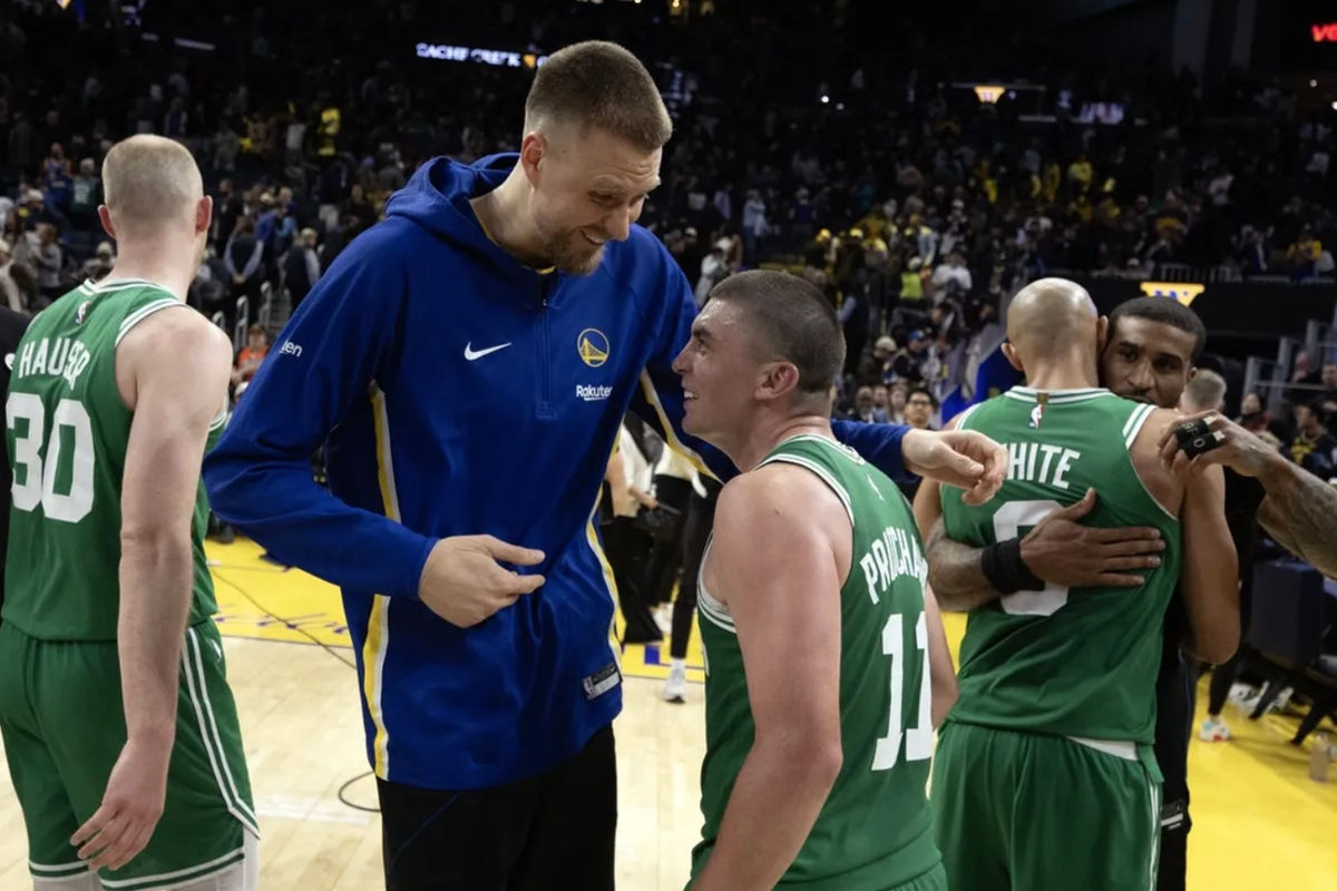 19 de fevereiro de 2026; São Francisco, Califórnia, EUA; O pivô do Golden State Warriors, Kristaps Porzingis (à esquerda), dá risada com o armador do Boston Celtics, Payton Pritchard (11), após a partida no Chase Center. Crédito obrigatório: D. Ross Cameron-Imagn Images