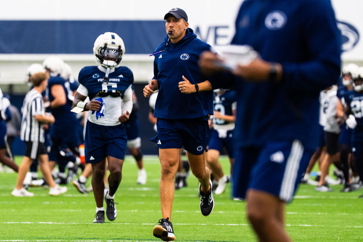 O treinador principal do time de futebol americano da Penn State, Matt Campbell, corre no início de um treino dentro do Holuba Hall, na segunda-feira, 10 de agosto de 2026, em State College.