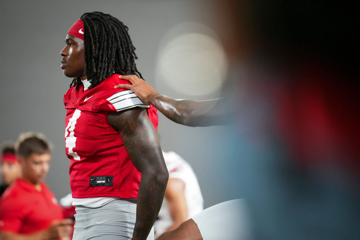 El receptor abierto de los Ohio State Buckeyes, Jeremiah Smith (4), se estira durante el campamento de entrenamiento de fútbol americano dentro del Woody Hayes Athletic Center en Columbus el 7 de agosto de 2026.