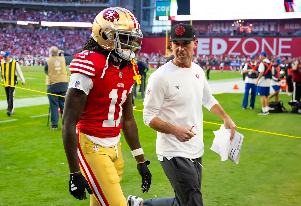 17 de dezembro de 2023; Glendale, Arizona, EUA; O técnico do San Francisco 49ers, Kyle Shanahan, conversa com o wide receiver Brandon Aiyuk (11) durante a partida contra o Arizona Cardinals no State Farm Stadium. Crédito obrigatório: Mark J. Rebilas-USA TODAY Sports