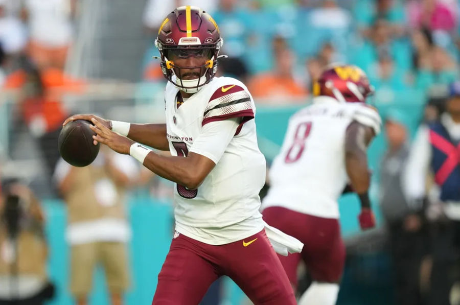 August 17, 2024; Miami Gardens, FL, USA; Washington Commanders quarterback Jayden Daniels (5) drops a pass during the first quarter against the Miami Dolphins at Hard Rock Stadium . Mandatory Credit: Jim Russo-USA TODAY Sports