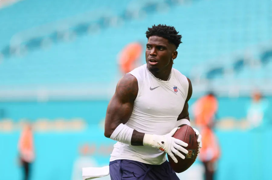 August 17, 2024; Miami Gardens, Florida, USA; Miami Dolphins wide receiver Tyreek Hill (10) throws a football before a preseason game against the Washington Commanders at Hard Rock Stadium. Mandatory Credit: Sam Navarro-Imagn Images