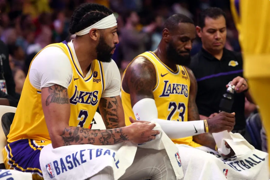 12 april 2024; Memphis, Tennessee, VS; Los Angeles Lakers-aanvaller Anthony Davis (3) en aanvaller LeBron James (23) zitten op de bank tijdens een time-out tijdens de tweede helft tegen de Memphis Grizzlies op FedExForum. Verplichte credits: Petre Thomas-Imagn Images