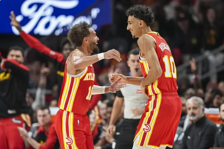 Oct 23, 2024; Atlanta, Georgia, USA; Atlanta Hawks forward Zaccharie Risacher (10) reacts with guard Trae Young (11) after making a three point basket for his first points in the NBA against the Brooklyn Nets during the first half at State Farm Arena. Mandatory Credit: Dale Zanine-Imagn Images