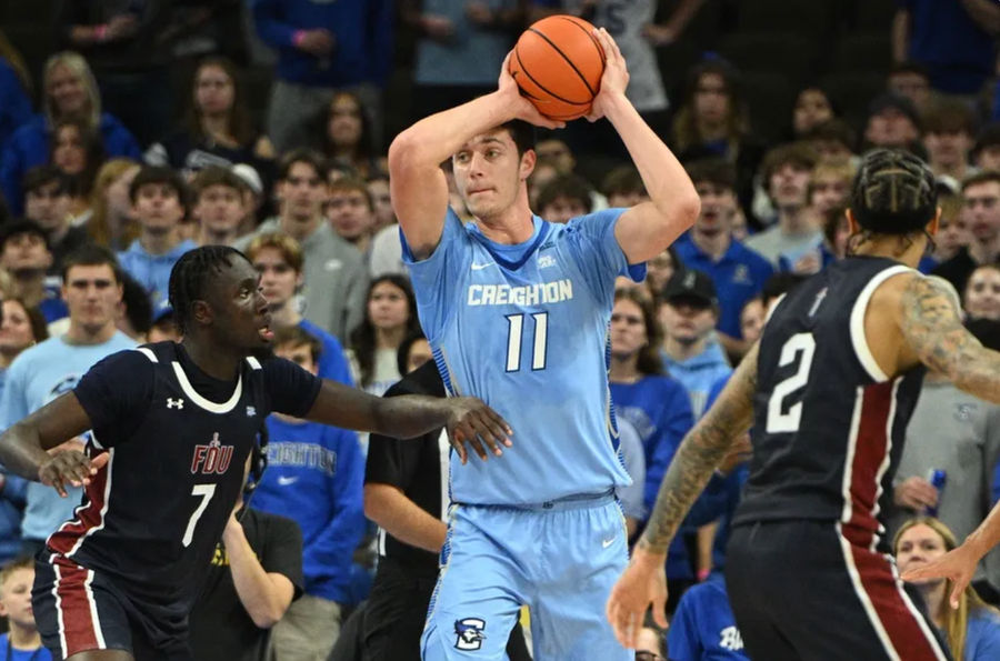 Nov 10, 2024; Omaha, Nebraska, USA; Creighton Bluejays center Ryan Kalkbrenner (11) passes against Fairleigh Dickinson Knights forward Bismark Nsiah (7) during the first half at CHI Health Center Omaha. Mandatory Credit: Steven Branscombe-Imagn Images