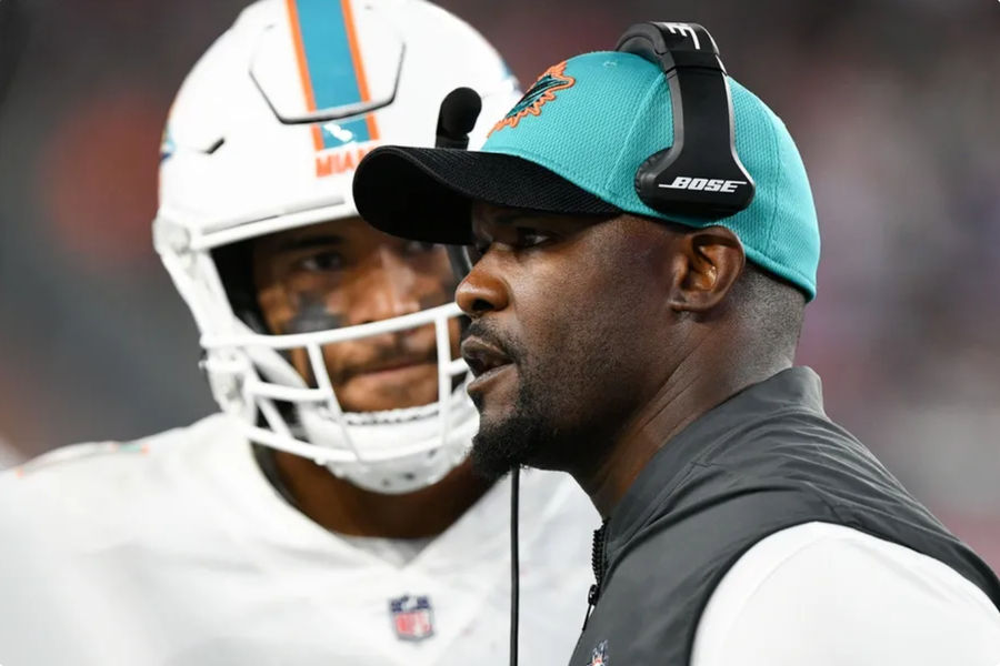 Former Miami Dolphins head coach Brian Flores talks with quarterback Tua Tagovailoa (1) in a game at the New England Patriots at Gillette Stadium. Mandatory Credit: Brian Fluharty-USA TODAY Sports