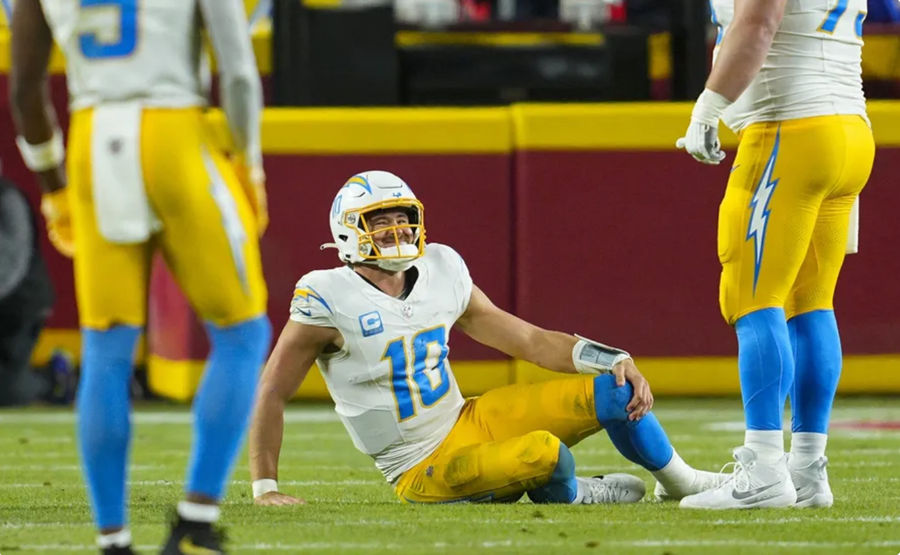 Dec 8, 2024; Kansas City, Missouri, USA; Los Angeles Chargers quarterback Justin Herbert (10) reacts after an injury during the first half against the Kansas City Chiefs at GEHA Field at Arrowhead Stadium. Mandatory Credit: Jay Biggerstaff-Imagn Images