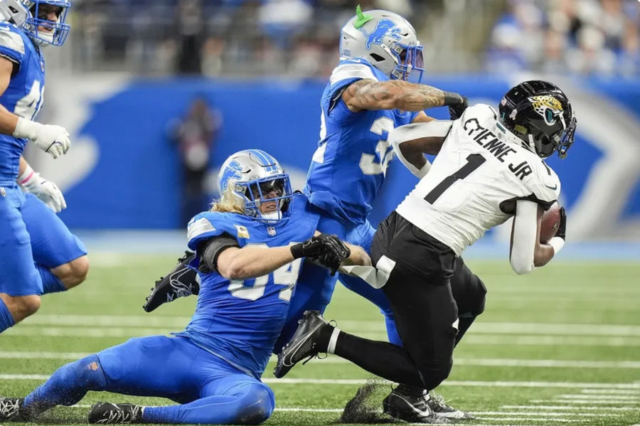 Nov 17, 2024; Detroit, MI, USA; Detroit Lions linebacker Alex Anzalone (34) and safety Brian Branch (32) tackle Jacksonville Jaguars running back Travis Etienne Jr. (1) during the first half at Ford Field in Detroit on Sunday, Nov. 17, 2024. Mandatory Credit: Junfu Han/USA TODAY Network via Imagn Images