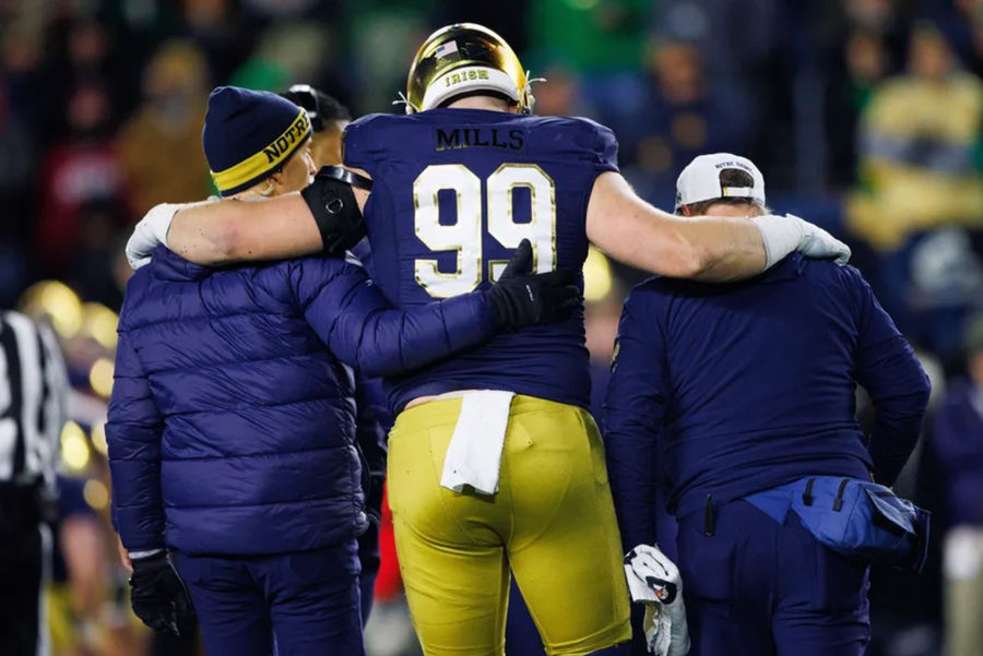 Notre Dame defensive lineman Rylie Mills (99) is helped off the field during the first round of the College Football Playoff between Notre Dame and Indiana at Notre Dame Stadium on Friday, Dec. 20, 2024, in South Bend. PHOTO USA TODAY SPORTS IMAGES.