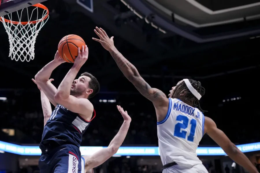 Jan 25, 2025; Cincinnati, Ohio, USA; Connecticut Huskies forward Alex Karaban (11) drives to the basket against Xavier Musketeers guard Dante Maddox Jr. (21) in the second half at the Cintas Center. Mandatory Credit: Aaron Doster-Imagn Images