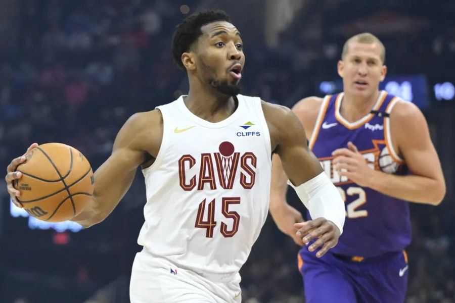 Jan 20, 2025; Cleveland, Ohio, USA; Cleveland Cavaliers guard Donovan Mitchell (45) drives to the basket beside Phoenix Suns center Mason Plumlee (22) in the first quarter at Rocket Mortgage FieldHouse. Mandatory Credit: David Richard-Imagn Images