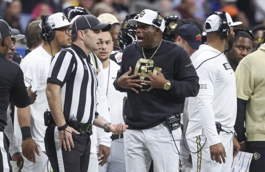 Dec 28, 2024; San Antonio, TX, USA; Colorado Buffaloes head coach Deion Sanders reacts with an official after a play during the second quarter against the Brigham Young Cougars at Alamodome. Mandatory Credit: Troy Taormina-Imagn Images