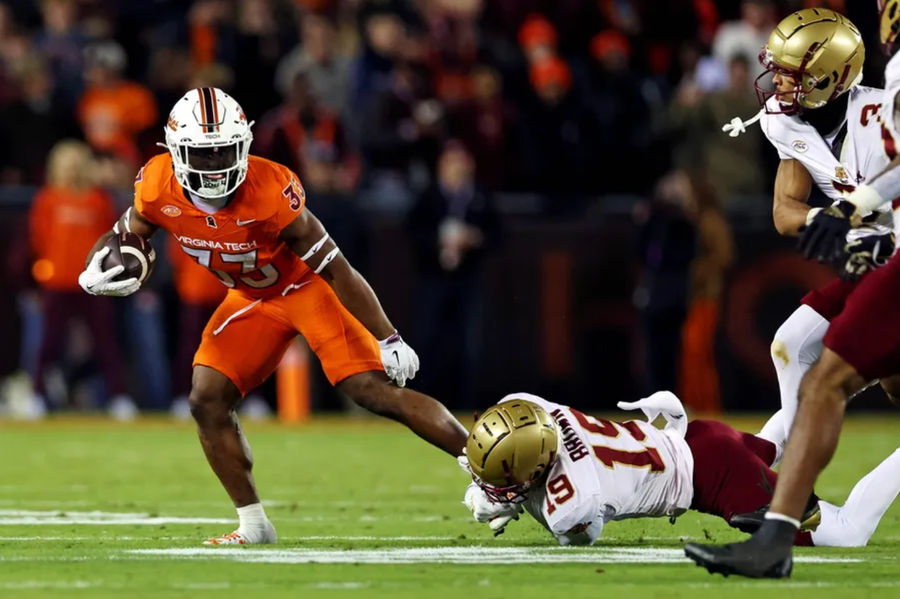 Oct 17, 2024; Blacksburg, Virginia, USA; Virginia Tech Hokies running back Bhayshul Tuten (33) runs the ball against Boston College Eagles cornerback Bryquice Brown (19) during the second quarter at Lane Stadium. Mandatory Credit: Peter Casey-Imagn Images