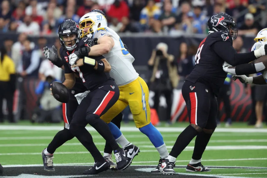 11 de enero de 2025; Houston, Texas, EE. UU.; El apoyador externo de Los Angeles Chargers, Joey Bosa (97), sacks, mariscal de campo de los Houston Texans, CJ Stroud (7) durante el primer cuarto en un juego de comodines de la AFC en el estadio NRG. Crédito obligatorio: Troy Taormina-Imagn Imágenes