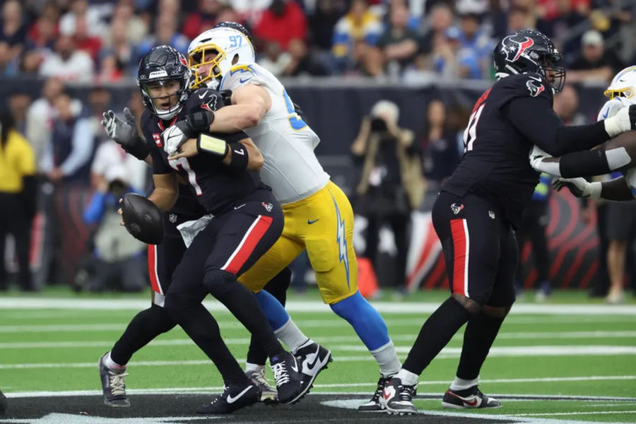 11 de janeiro de 2025; Husson Texas EUA; Los Angeles Charge, a equipe, Bonongko Joey Bosa (97), Husson Texas Sack, CJ Stroud (7) no primeiro trimestre no Wild Card AFC no NRG Stadium.