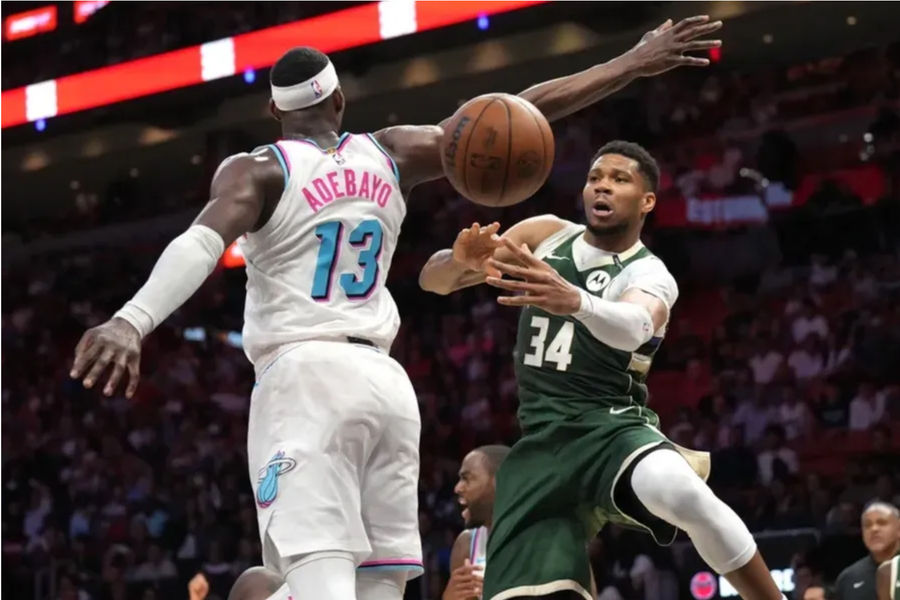 April 5, 2025; Miami, Florida, USA; Milwaukee Bucks Advanced Giannis Anthetokounmpo (34) passes under the arm of Miami Heat Center Bam Adebayo (13) during overtime in Kaaya Center. Compulsory Credit: Jim rassol-imagn images