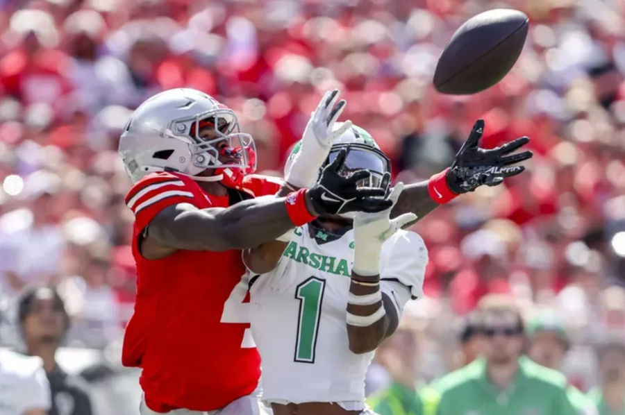 Sep 21, 2024; Columbus, Ohio, USA; Ohio State Buckeyes wide receiver Jeremiah Smith (4) goes for the ball with Marshall Thundering Herd defensive back Josh Moten (1) during the first quarter at Ohio Stadium. Mandatory Credit: Joseph Maiorana-Imagn Images